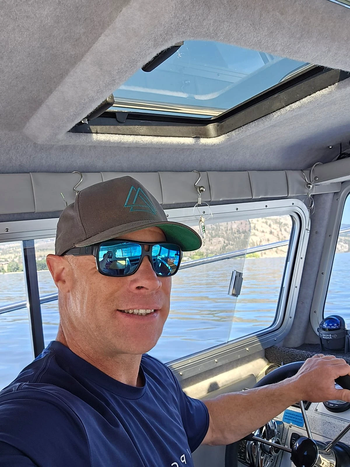 Captain Dennis Barnes at the helm of the Kingfisher on Okanagan Lake