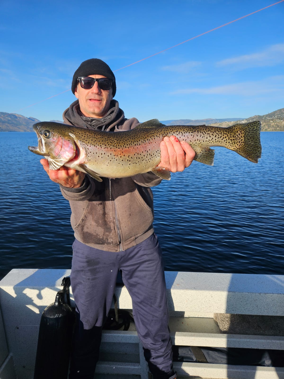 Trophy rainbow trout held by happy guest