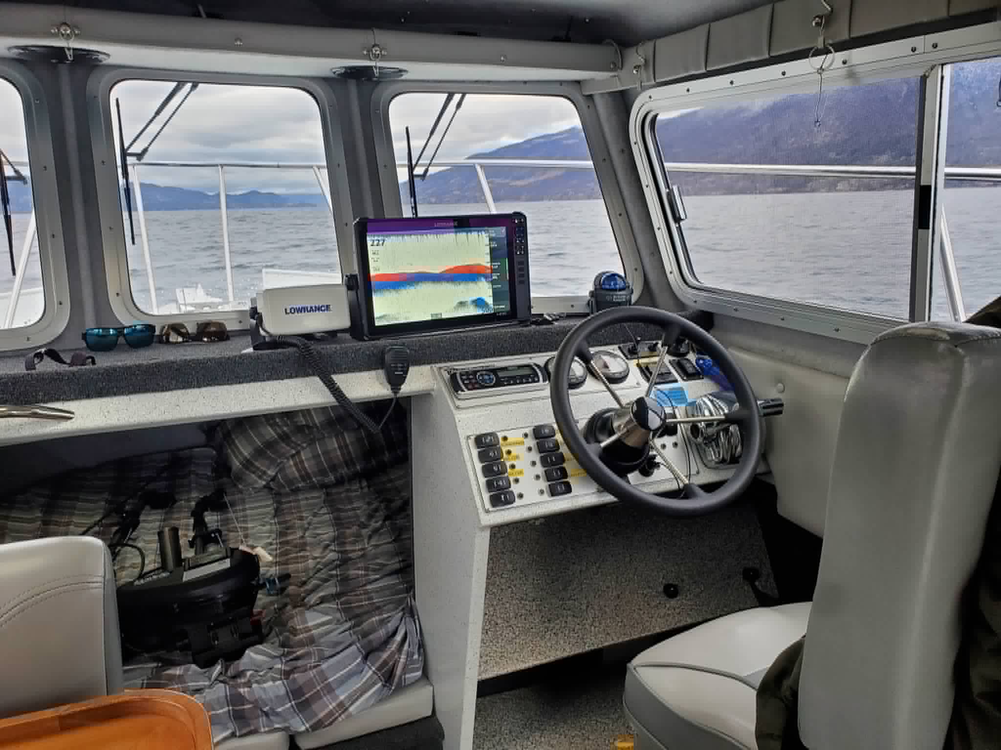 Charter boat helm with Lowrance fishfinder showing marks