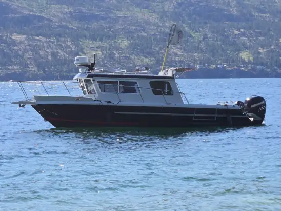 Kingfisher 2525 Weekender on Okanagan Lake, side profile with the mountains behind