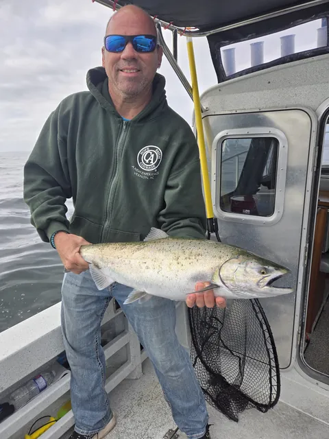 Guest with a chinook salmon aboard the boat